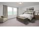 Serene main bedroom with large window, neutral color palette, carpet flooring, and coordinating bedside tables and lamps at 153 Gladstone Loop, Clayton, NC 27520