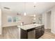 Open kitchen with island, stainless steel appliances, and wood-look floors at 157 Willow Grove Ln, Fuquay Varina, NC 27526