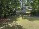 View of grassy backyard with a partial fence and mature trees for shade at 1704 Southgate St, Durham, NC 27703