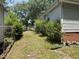 View of the side of the house with some overgrown bushes and a chainlink fence in the backyard at 1704 Southgate St, Durham, NC 27703