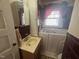 This bathroom has a shower tub combo, a mirror, sink and red colored tiling at 1704 Southgate St, Durham, NC 27703