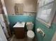 This bathroom features blue tiling, a toilet, sink, and a window for natural light at 1704 Southgate St, Durham, NC 27703