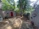 View of a backyard featuring a storage shed, wooden fence, tree, string lights, and garden decorations at 1708 Quail Ridge Rd, Raleigh, NC 27609