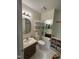 Cozy bathroom with tile floor, oval mirror, open storage shelves and modern commode at 1708 Quail Ridge Rd, Raleigh, NC 27609