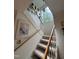 Carpeted staircase with wooden handrails and a large window offering natural light at 1708 Quail Ridge Rd, Raleigh, NC 27609