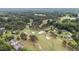 A comprehensive aerial perspective of real estate adjacent to a manicured golf course amidst a lush, tree-filled landscape at 174 Woodwedge Way, Sanford, NC 27332
