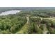 Expansive aerial view showcasing the community's lush greenery, lake, and winding roads, offering a serene and picturesque setting at 174 Woodwedge Way, Sanford, NC 27332