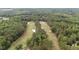 Aerial view of lush green golf course and wooded landscape surrounding the real estate location at 174 Woodwedge Way, Sanford, NC 27332