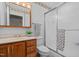 Bathroom featuring an oak vanity, a shower with glass doors, and floral wallpaper at 174 Woodwedge Way, Sanford, NC 27332