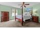 Elegant primary bedroom with a four-poster bed, wood dresser, and neutral carpet at 174 Woodwedge Way, Sanford, NC 27332