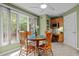 Cozy breakfast nook featuring large windows, a round wooden table, and built-in cabinetry with workspace at 174 Woodwedge Way, Sanford, NC 27332