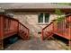 Dual staircases rise to the deck, flanked by red railings, creating symmetrical access from the brick-paved ground below at 174 Woodwedge Way, Sanford, NC 27332