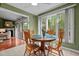 Cozy dining area with a round wooden table and chairs, bathed in natural light from the large windows at 174 Woodwedge Way, Sanford, NC 27332