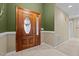 Elegant wooden double doors featuring decorative glass panels, inside a brightly lit foyer with neutral tile flooring at 174 Woodwedge Way, Sanford, NC 27332