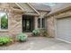 Charming brick home featuring a quaint front entrance with decorative plants and a welcoming wreath on the door at 174 Woodwedge Way, Sanford, NC 27332