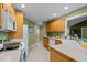 Well-lit kitchen featuring light wood cabinets, a white dishwasher, and a view into the hallway at 174 Woodwedge Way, Sanford, NC 27332