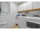 Clean laundry room with modern appliances, upper cabinets, and a small window for natural light at 174 Woodwedge Way, Sanford, NC 27332