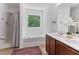 Bright bathroom featuring a double sink vanity, tub with shower, and a window with a view at 194 Catskill Ct, Burlington, NC 27217