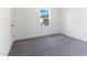 This empty bedroom with neutral carpet features a window bringing in natural light at 194 Catskill Ct, Burlington, NC 27217