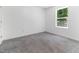 This vacant bedroom with neutral carpet features a window bringing in natural light at 194 Catskill Ct, Burlington, NC 27217