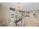 Elegant dining room with a chandelier and glass table with seating for six at 1973 Elon Ossipee Rd, Elon, NC 27244