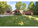 Beautiful brick home with multiple entrances, surrounded by a green lawn and mature trees at 1973 Elon Ossipee Rd, Elon, NC 27244