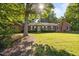 Charming single-story brick home with a well-manicured lawn, welcoming entrance, and mature landscaping under a sunny sky at 1973 Elon Ossipee Rd, Elon, NC 27244
