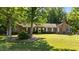Charming brick home featuring a lush green lawn and mature trees for shade at 1973 Elon Ossipee Rd, Elon, NC 27244