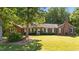 A charming brick home with mature trees and a well-manicured lawn at 1973 Elon Ossipee Rd, Elon, NC 27244