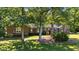 A brick home shaded by mature trees on a lush green lawn at 1973 Elon Ossipee Rd, Elon, NC 27244