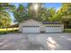 Three car garage with a covered carport and ample parking space on a sunny day at 1973 Elon Ossipee Rd, Elon, NC 27244