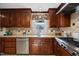 Close up of the kitchen sink and counter, showing stainless steel appliances and wood cabinetry at 1973 Elon Ossipee Rd, Elon, NC 27244