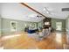 Spacious living room with a stone fireplace, hardwood floors, and large windows offering natural light at 1973 Elon Ossipee Rd, Elon, NC 27244