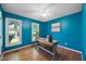 Office featuring blue walls, wood floors, and a writing desk by two windows at 1973 Elon Ossipee Rd, Elon, NC 27244