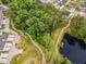 An aerial view of a neighborhood featuring a pond, walking trails, and a wooded area with established trees at 2009 Latham Oaks Ave, Wake Forest, NC 27587