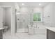 Bathroom featuring glass-enclosed shower, soaking tub, and marble-look tiling at 2009 Latham Oaks Ave, Wake Forest, NC 27587