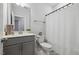 Cozy bathroom featuring a vanity with gray cabinets, toilet, and shower with a white curtain at 2009 Latham Oaks Ave, Wake Forest, NC 27587