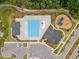 Aerial view of a community pool, playground, and pool house surrounded by landscaped grounds and a walking path at 2009 Latham Oaks Ave, Wake Forest, NC 27587