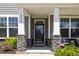 Charming front porch with stone pillars, seating, and a view of the manicured lawn at 2009 Latham Oaks Ave, Wake Forest, NC 27587