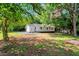 Spacious backyard featuring a white home exterior, green grass, and mature trees at 2085 Enon Rd, Oxford, NC 27565