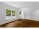 Bright, empty room featuring hardwood floors, fresh white paint, and large windows at 2085 Enon Rd, Oxford, NC 27565