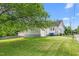 View of the home's backyard, garage, and leafy trees from the street at 219 W Parker St, Graham, NC 27253