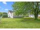 Exterior view of a large backyard with lush green grass and mature trees at 219 W Parker St, Graham, NC 27253