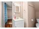 This is a small bathroom with a vanity, square mirror, and a shower-tub with a blue curtain at 219 W Parker St, Graham, NC 27253