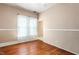 This is an empty bedroom with hardwood floors, two windows with blinds, and some natural light at 219 W Parker St, Graham, NC 27253