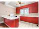 The kitchen has a tile floor with red cabinets, white countertops, and a view of the front yard at 219 W Parker St, Graham, NC 27253