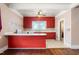 The kitchen has a view into an adjacent room and a tile floor and vintage red cabinets at 219 W Parker St, Graham, NC 27253
