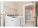 This is a laundry room with a Samsung washer and dryer, metal shelving, and a view into an adjacent bathroom at 219 W Parker St, Graham, NC 27253