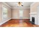 Empty living room boasting hardwood floors, a fireplace, and bright windows, ready for personalization at 219 W Parker St, Graham, NC 27253