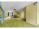 Spacious living room featuring green carpet, retro yellow walls, and a ceiling fan at 219 W Parker St, Graham, NC 27253
